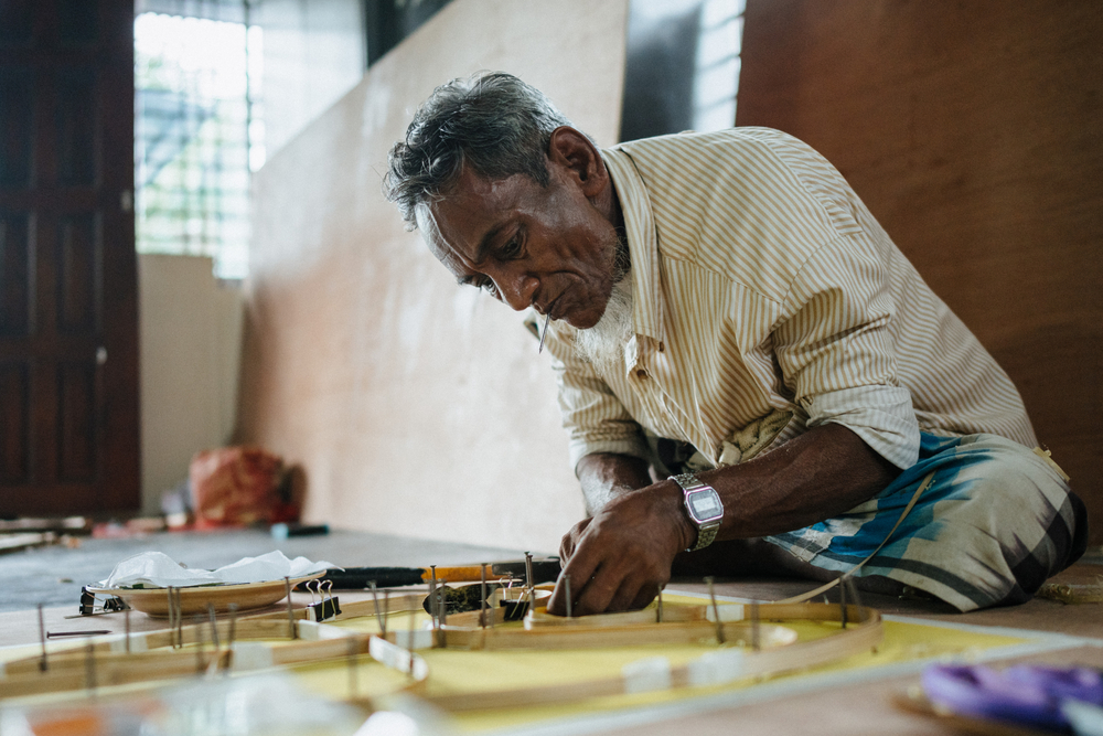 A Rohingya man creates a taro leaf artwork symbolising the Rohingya refugee experience.