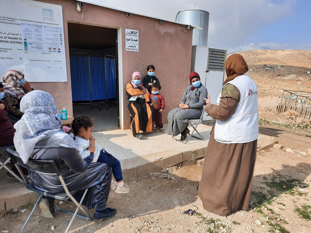 : Yasmin Jamal Mahmoud Abu Mustafa, petugas kesihatan komuniti MSF berbicara dengan beberapa waris di sebuah klinik bergerak MSF di Masafer Yatta, Hebron (Palestin) @   MSF/Katharina Lange 