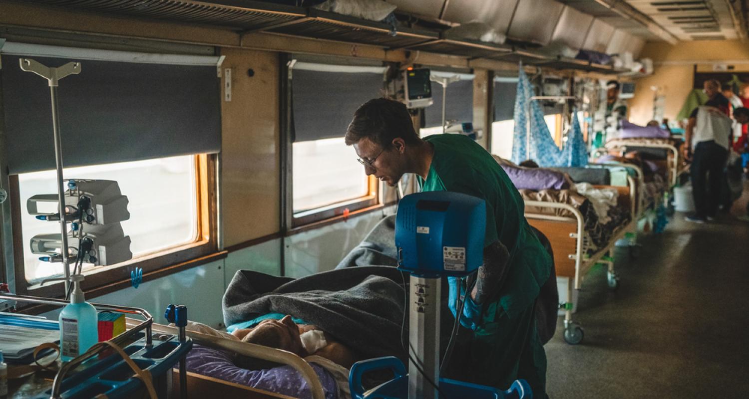 MSF nurse aid, Dmytro Mohylnytskyi, monitors a war-wounded patient inside the intensive care unit (ICU) of the MSF medical team during a journey from Pokvrosk in eastern Ukraine, to Lviv in western Ukraine.