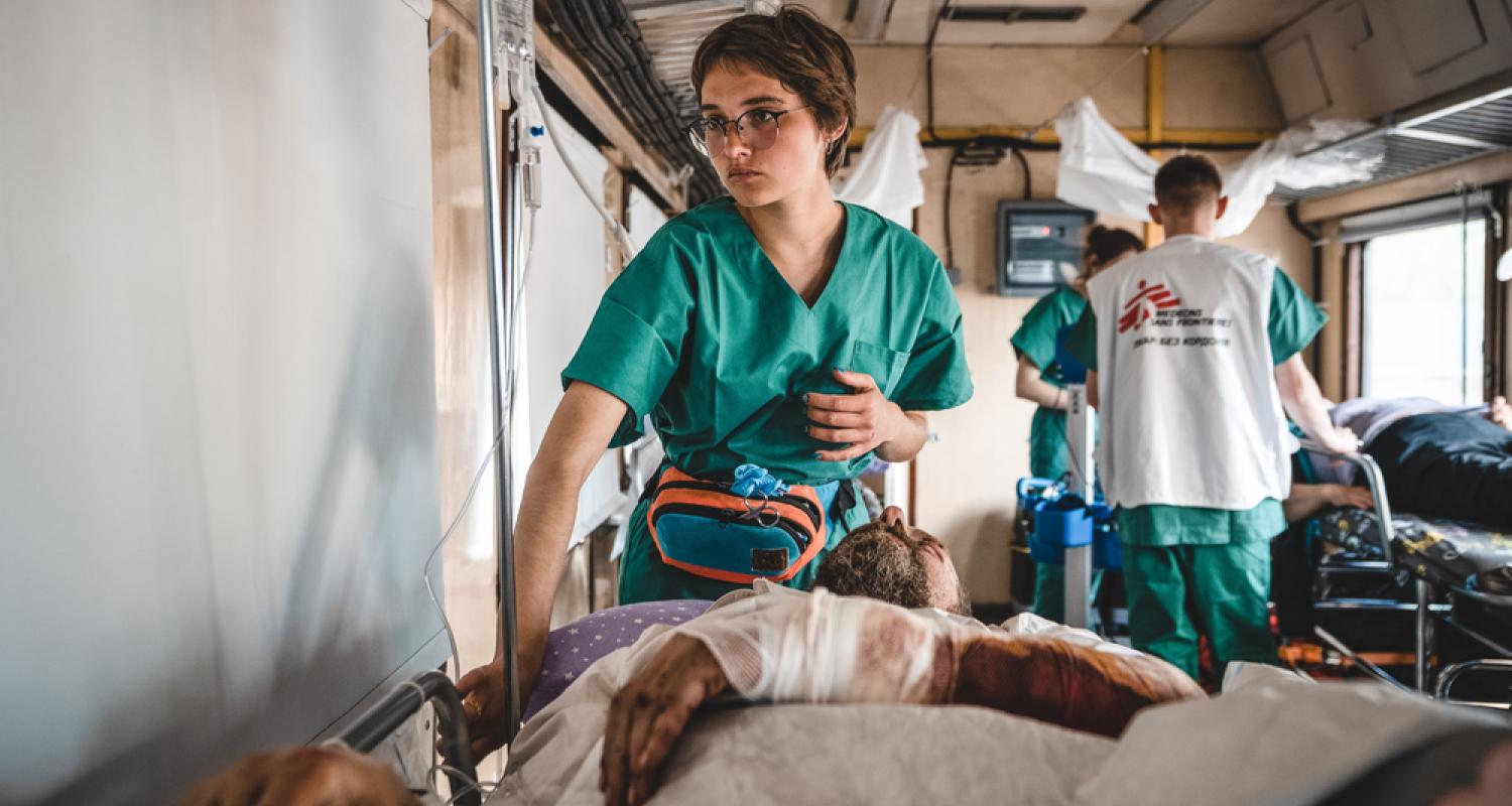 Doctors Without Borders nurse monitors a war-wounded patient inside the inpatient department of the medical team during a journey from Pokrovsk, in eastern Ukraine, to Lviv in western Ukraine. Ukraine, May 2022. © Andrii Ovod