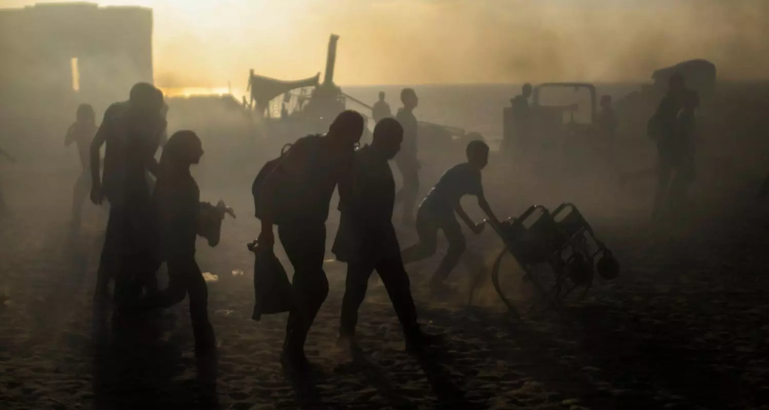Silhouettes of Palestinians at a GHF aid distribution site