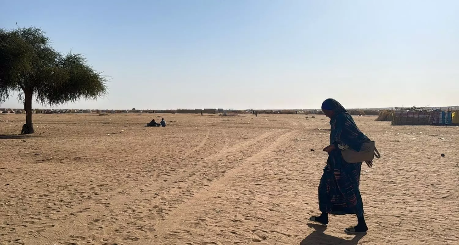 A woman walks through Daba Naira camp for internally displaced people in Tawila