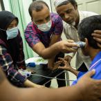 Kairul, a Rohingya man who fell two floors while working at a construction site, is examined by a nurse ahead of his doctor’s appointment at MSF’s clinic in Penang. @Arnaud Finistre