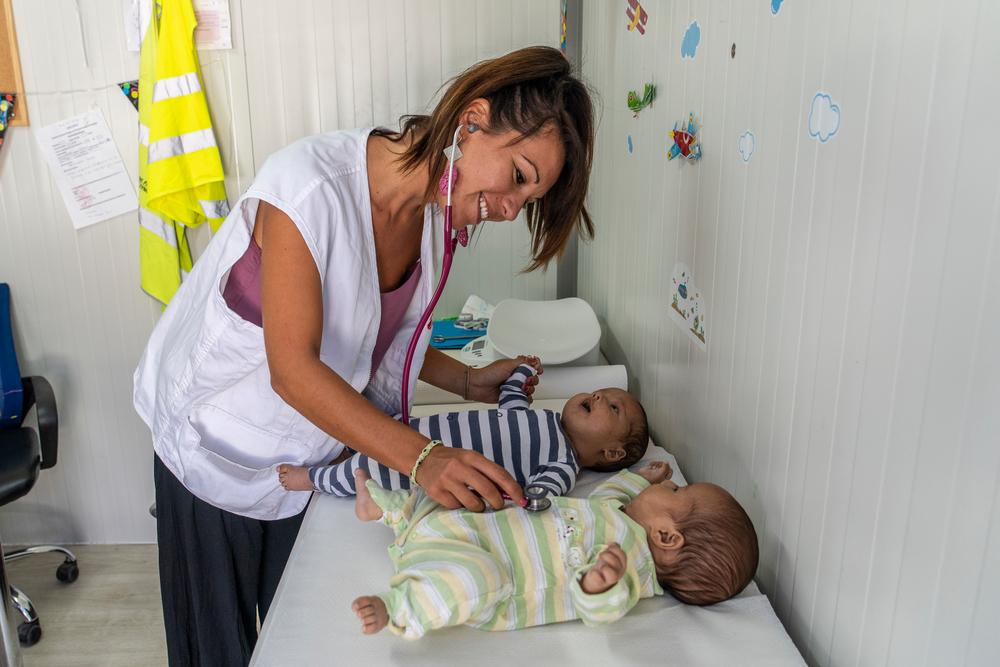 MSF's pediatrician, Carola Buscemi, examines a pair of 3 month old twins from Afghanistan. C- Anna Pantelia/MSF 