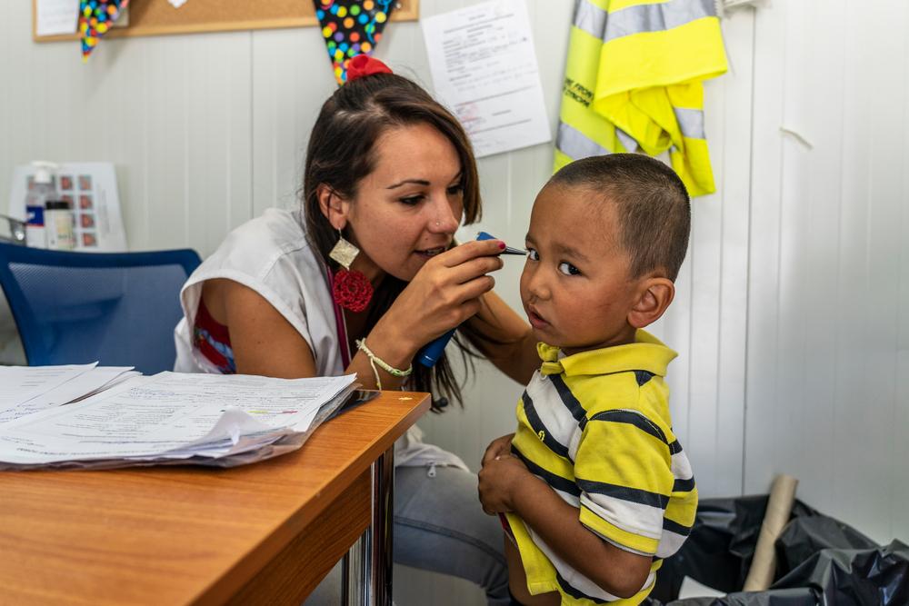 MSF's pediatrician, Carola Buscemi, examines an Afghan boy. C - Anna Pantelia