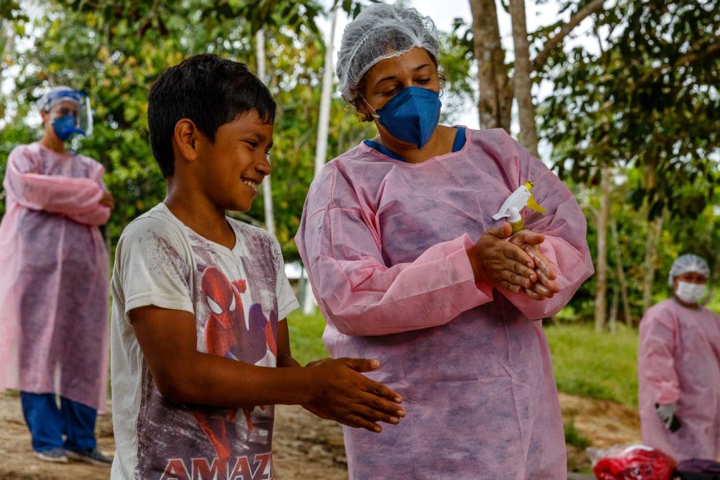 Nurse Nara Duarte teaches a child the correct way to perform hand hygiene in a community visited by the MSF and municipal health system's staff in Lake Mirini. ©Diego Baravelli/MSF