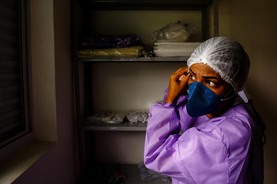 A health worker wears the personal protective equipment before entering the control area of the MSF care center for mild and moderate cases of COVID-19 in São Gabriel da Cachoeira. ©Diego Baravelli/MSF