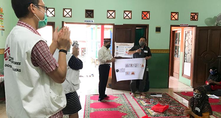 During the COVID-19 training for the community, the participants were divided into small groups. In the picture, one group presented their discussion results to the rest of the participants. © Cici Riesmasari/MSF