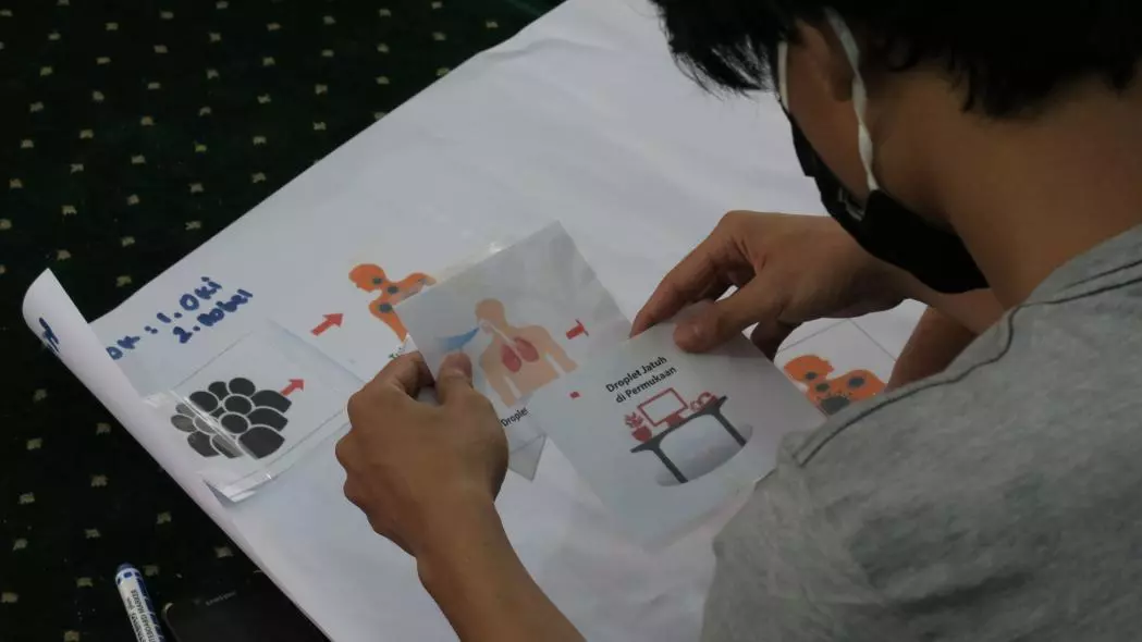 One of the participants trying to figure out the correct flow of the flash cards on COVID-19 virus spread. The COVID-19 training was conducted by the MSF medical team and was attended by the adolescents in Kalibata Sub-district, Kalibata Village in South Jakarta, Indonesia. ©Sania Elizabeth/MSF