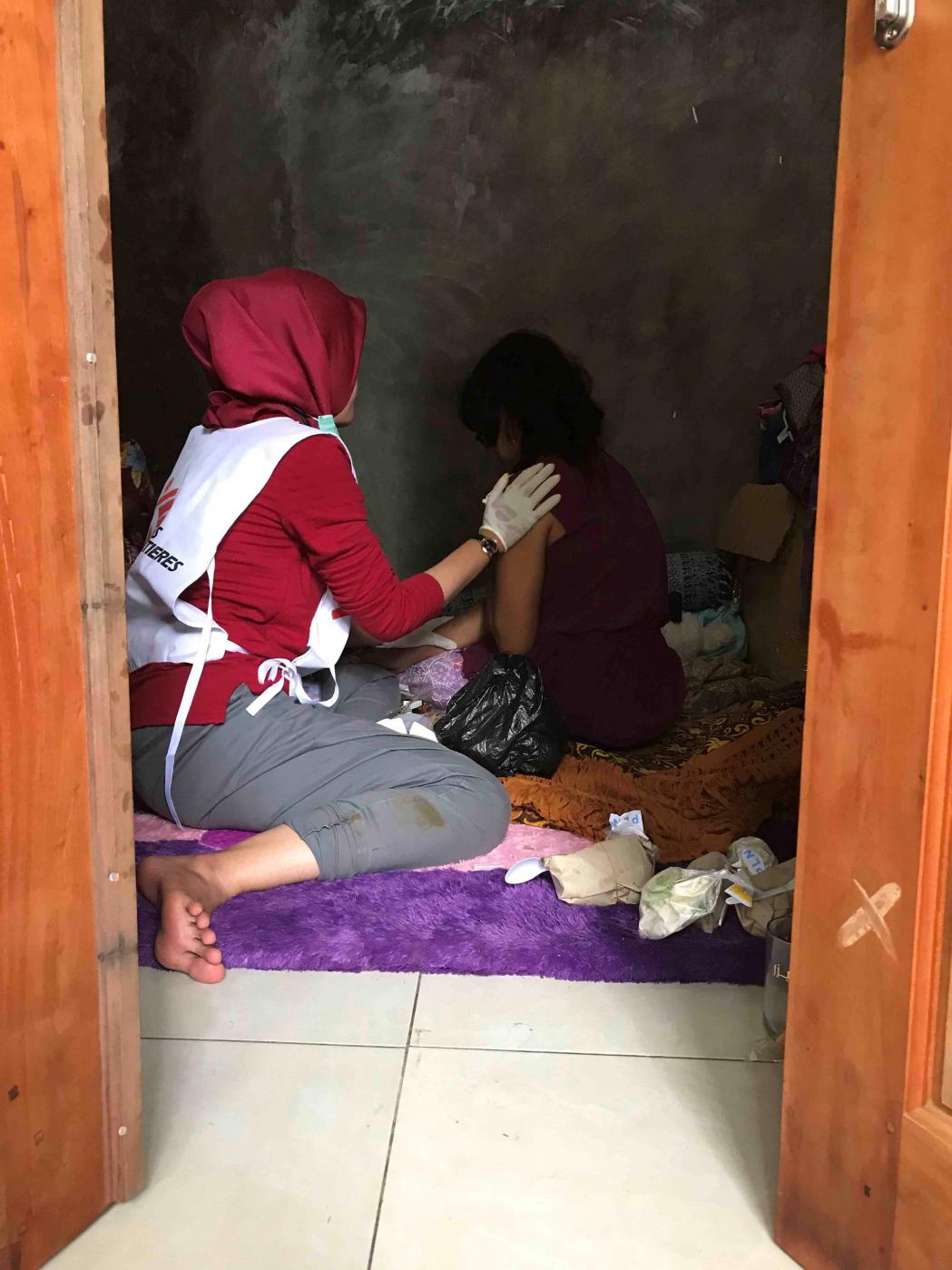 This MSF midwife is dressing the wounds of a 2018 tsunami survivor in the shelter. © Cici Riesmasari/MSF