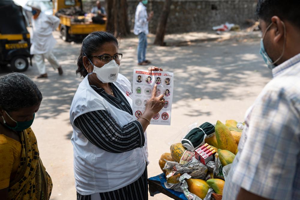ealth Educator conducting educational talk on mask management with a street hawker in M-East Ward, Mumbai.