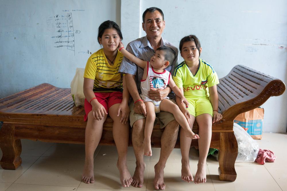 Din Savorn, 50, poses with his children at his apartment in Phnom Penh, Cambodia. April 2017. © Todd Brown
