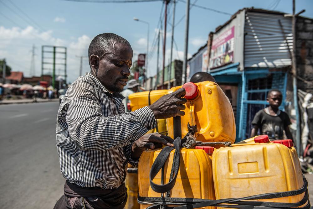 Jean-Claude Bazibuhe, water seller in the city of Goma, fills a gallon with water at Nyabushongo neighbourhood.