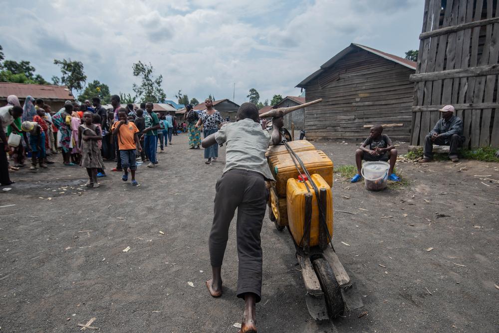A man transports jerrycans in a tschukudu, a wooden bike used in Goma region, DRC.