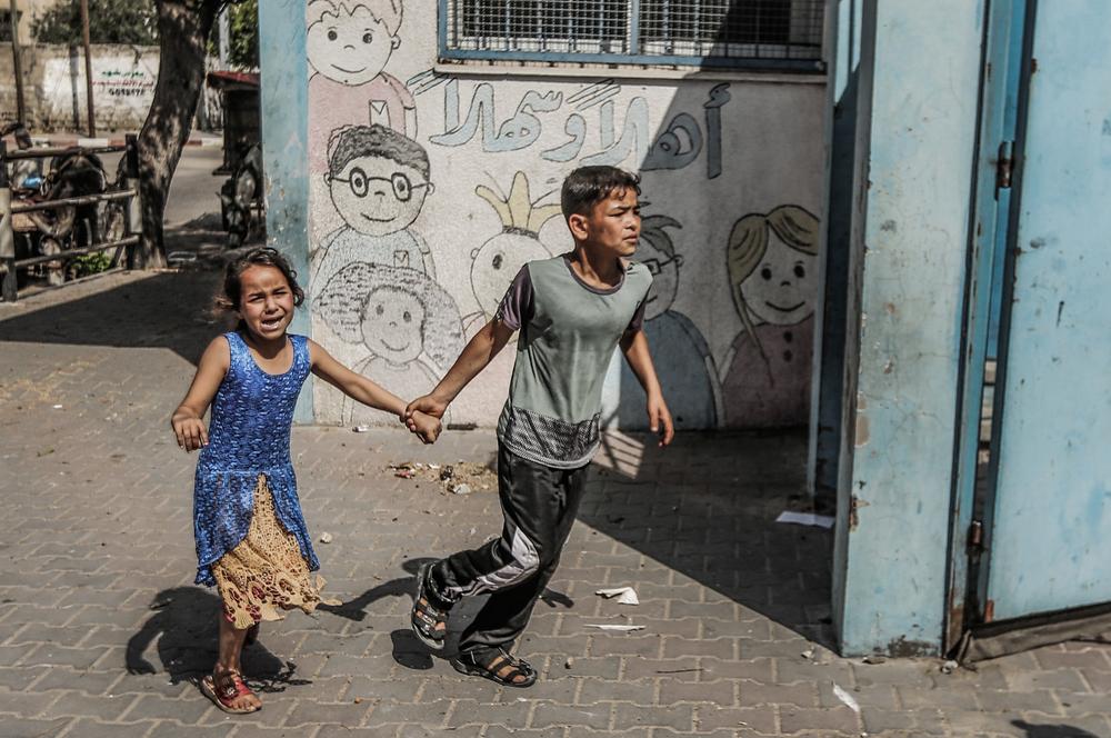 Children run on a street of Gaza city. Of the 2 million Palestinians living in Gaza, over 40 per cent are children aged 14 or under. These children have lived their entire lives under Israeli blockade, survived four major offensives by Israel and experience repetitive and ongoing trauma. 