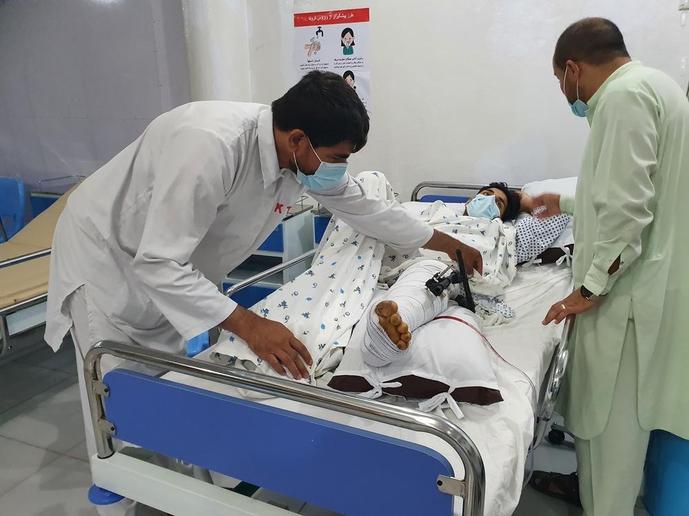 Emergency room of the MSF Kunduz Emergency Trauma Unit, a medic treats a patient who has suffered a complicated fracture of their upper and lower leg due to a bomb blast 
