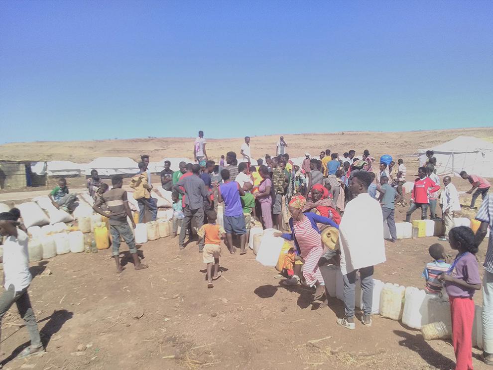 People queuing for water in Um Rakuba refugee camp after there was no supply for two days.