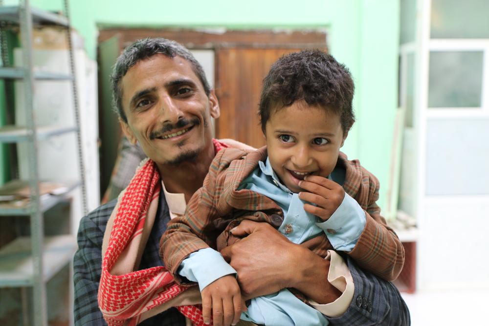 Hamdan and his son Hashid share a smile as Hamdan bidding farewell to the medical staff after completing his treatment at waiting area of the mental health clinic supported by MSF at Al-Gamhouri Hospital in Hajjah.