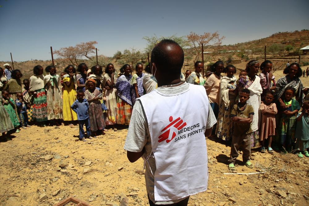 MSF translator Tedros gives instructions to women waiting with their children for a medical consultation at a mobile clinic in the village of Adiftaw