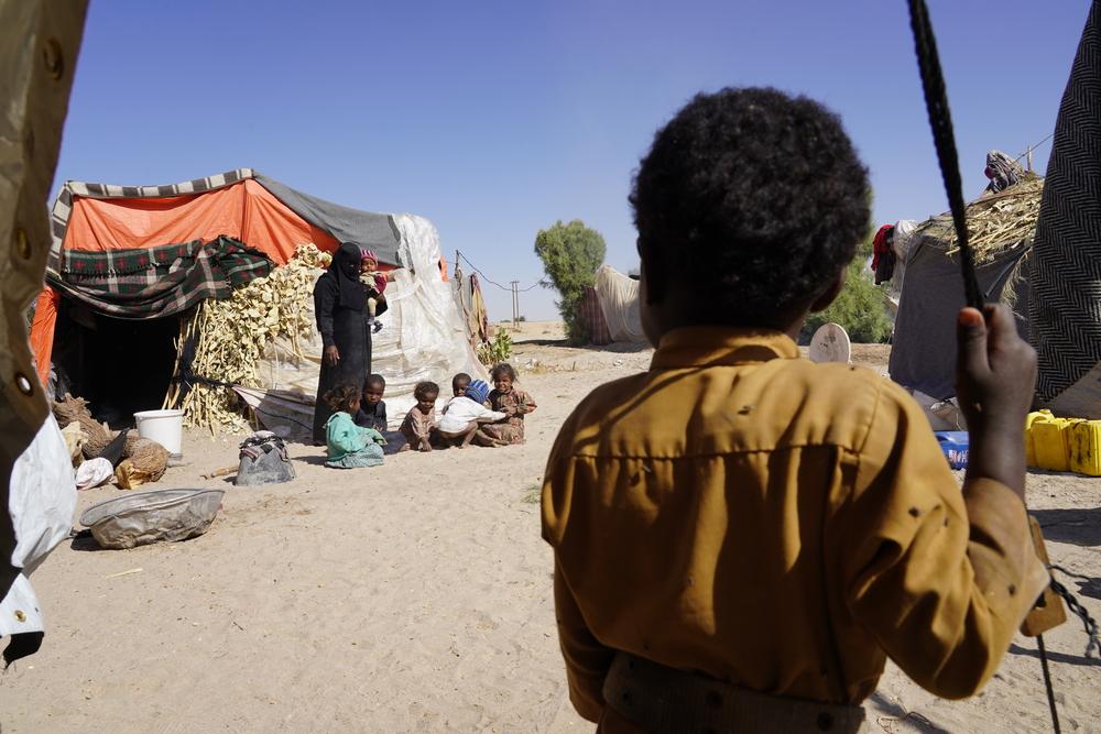 Children sit outside their tent in Al-Khuseif camp for internally displaced people in Marib.