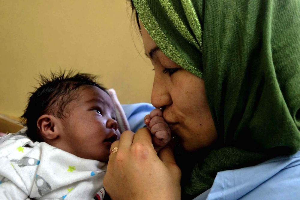 A proud, happy mother kisses her baby’s hand in Dasht-e-Barchi’s New Born Unit