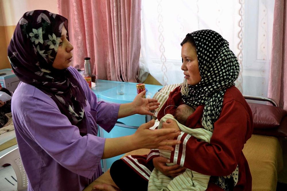 A healthcare staf assists a new mother at Dasht-e-Barchi’s Kangaroo Mother Care Unit.