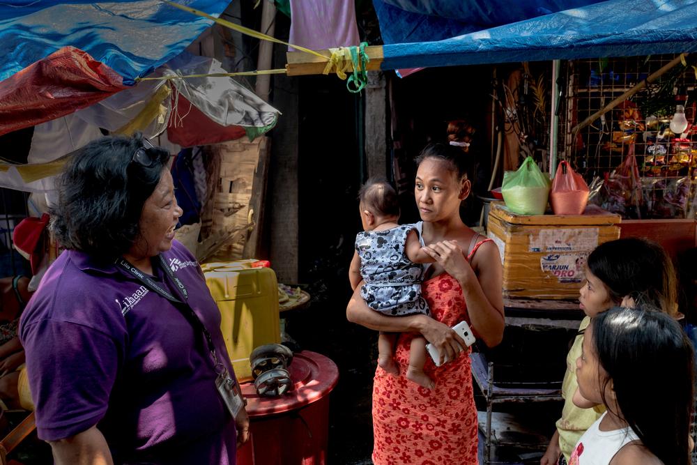 22-year-old Rosalita, who has two children, receives family planning advice with an MSF health promotion officer in the Tondo neighbourhood of Manila