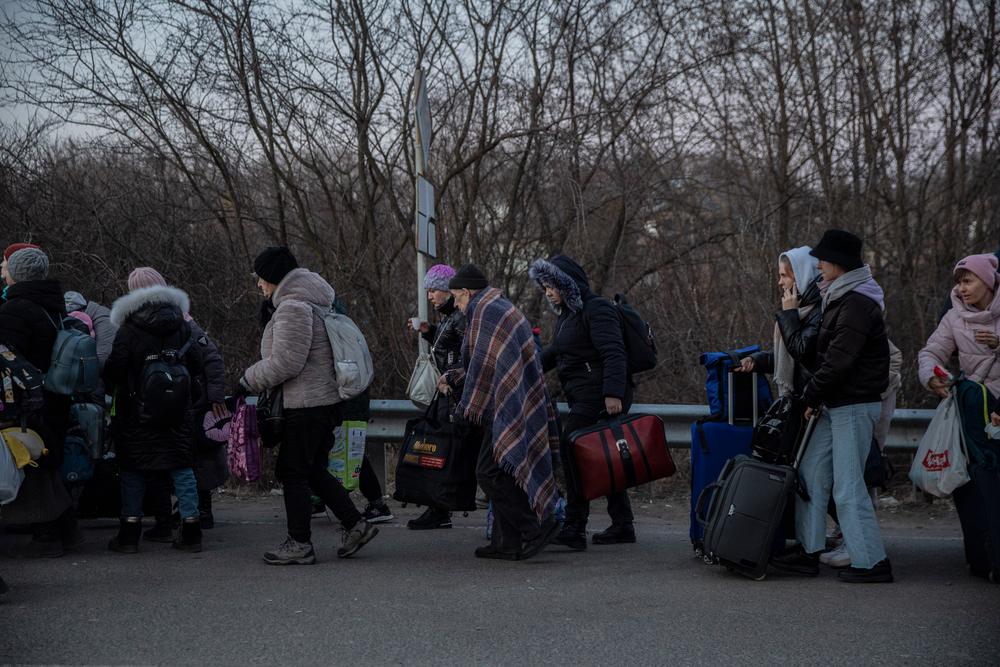 Hundreds of people wait in line to cross the border on foot into Slovakia from the city of Uzhhorod in Ukraine's Transcarpathia region. 