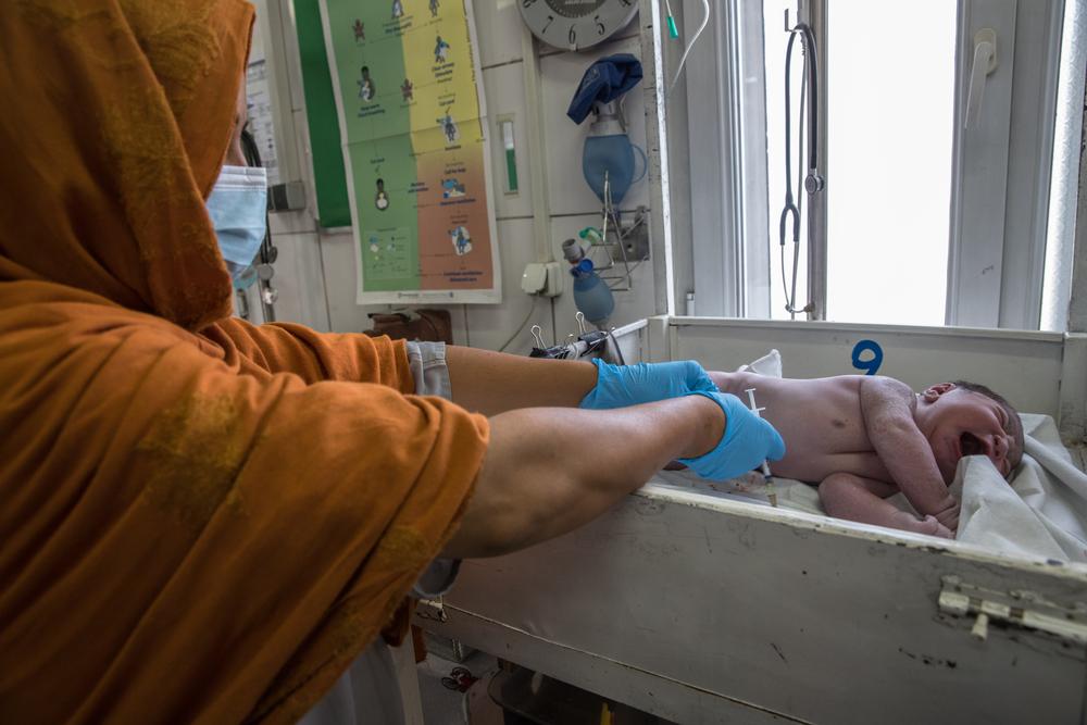 An MSF midwife assistant cares for a baby in the delivery room at the MSF Khost maternity hospital.