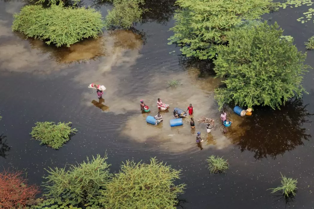 Families heading to dry land in Bentiu. 835,000 people have been directly affected by the flooding. South Sudan, 2021.