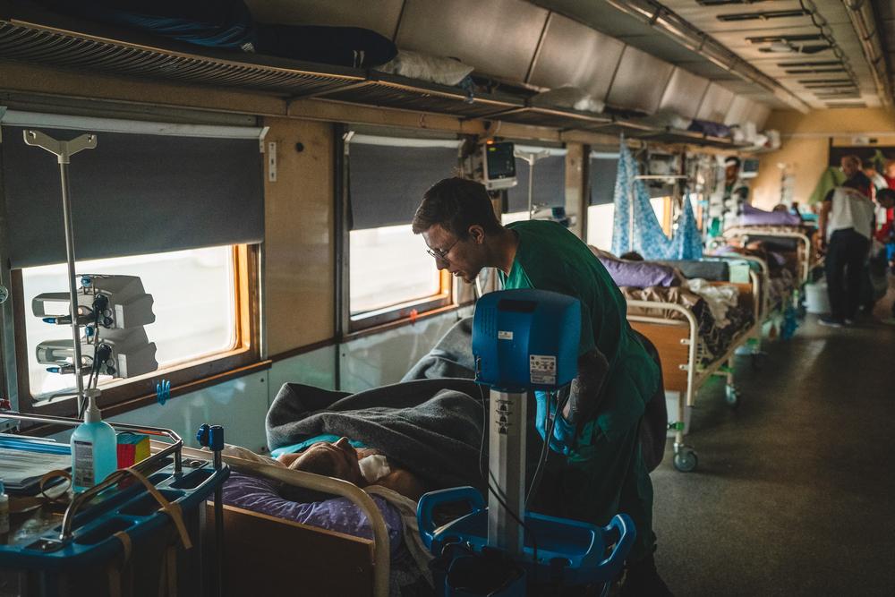 MSF nurse aid, Dmytro Mohylnytskyi, monitors a war-wounded patient inside the intensive care unit (ICU) of the MSF medical team during a journey from Pokvrosk in eastern Ukraine, to Lviv in western Ukraine.