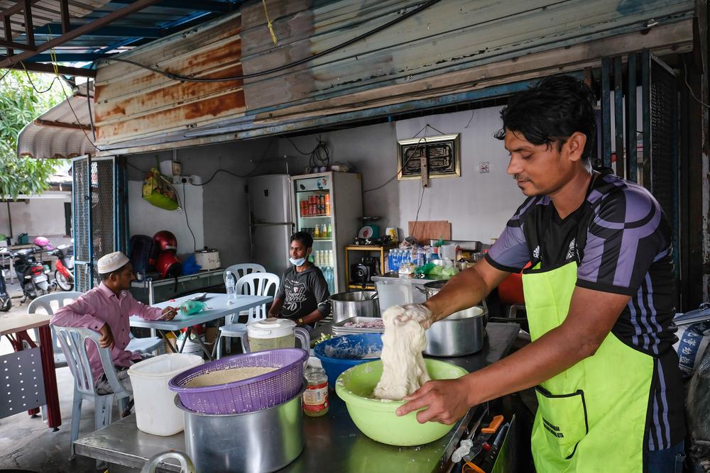 Juhar Suhinamia, 25, mixes the dough to make fried sweet balls.