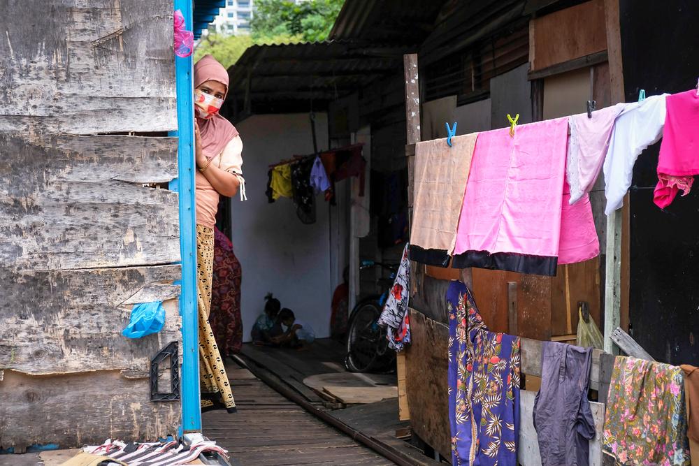 Anuar Begum Abdul Malik, 42, is looking out of the door of her home at Georgetown, Penang.