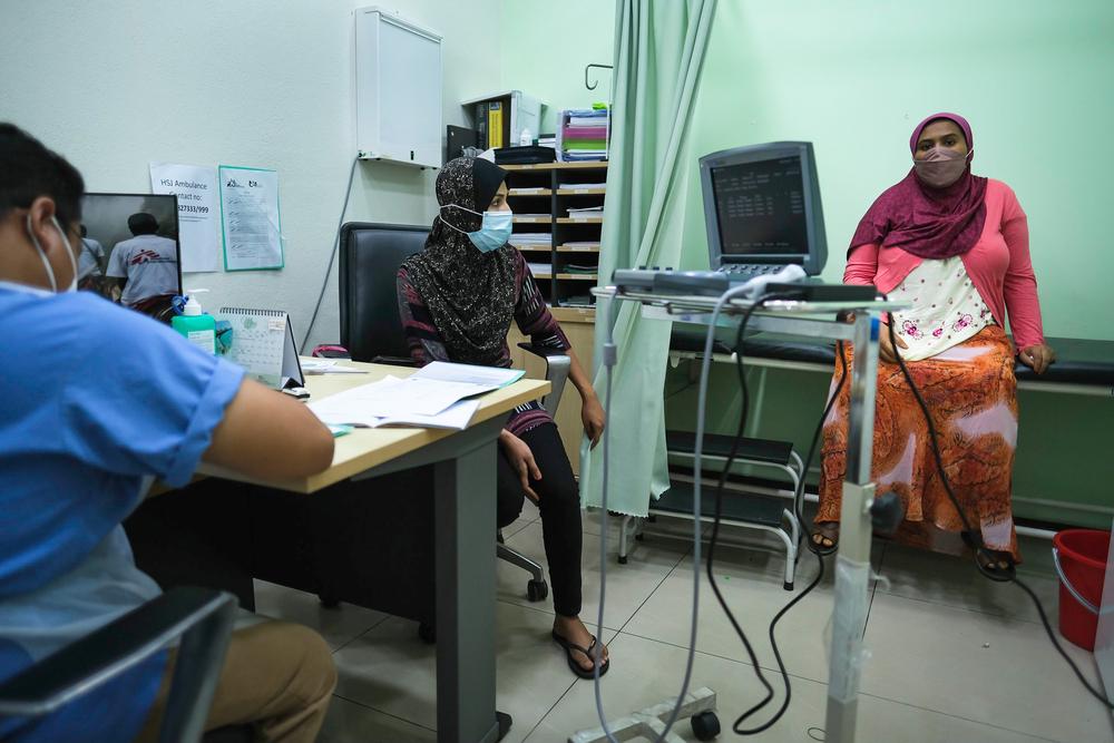 A patient from the Rohingya community in Malaysia explaining her symptoms to the doctor.