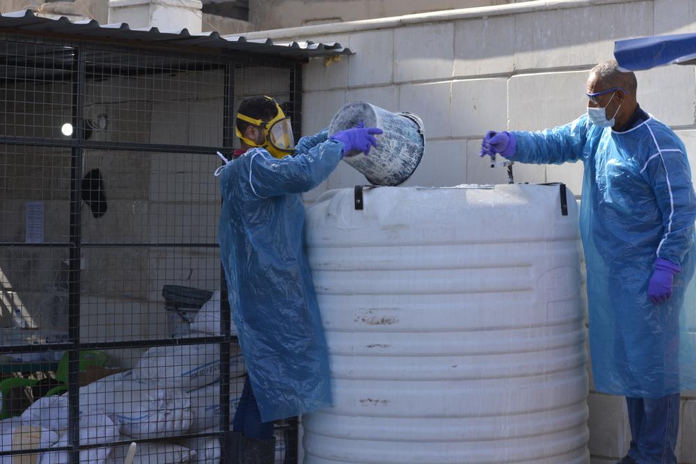 A water and sanitation team mixes lime with fecal sludge from the cholera treatment center in order to eliminate Vibrio cholera, Raqqa, northeast Syria.
