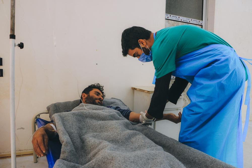 A healthcare worker checking-up on Mohamad Al-Merhi, a Cholera patient in the MSF-supported Cholera Treatment Unit (CTU) in Idlib governorate, northwest Syria. Syria, November 2022. © Abd Almajed Alkarh/MSF 