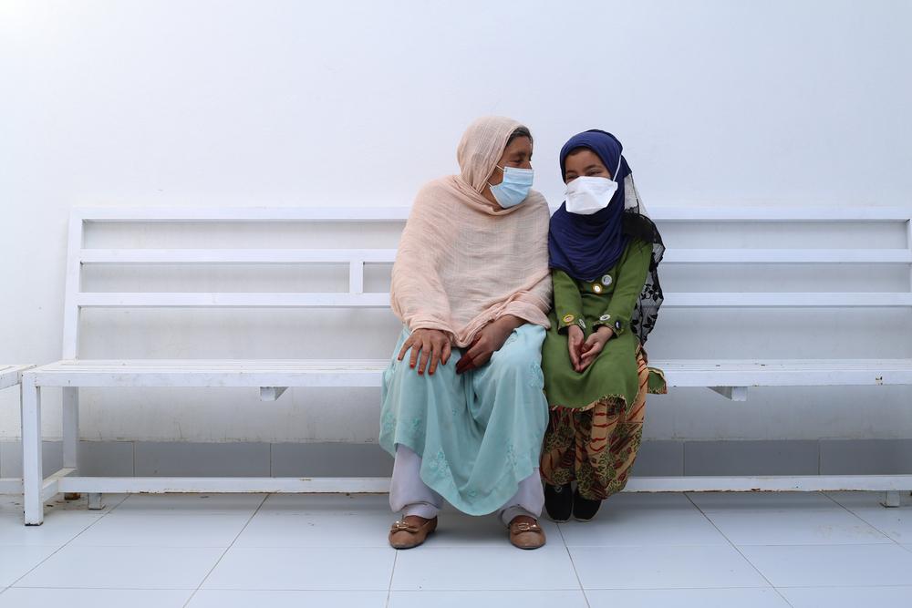 A patient with her granddaughter in the waiting room on the women's side of our drug-resistant tuberculosis (DR-TB) hospital in Kandahar city, Kandahar Province. Afghanistan, 2022. © Lynzy Billing
