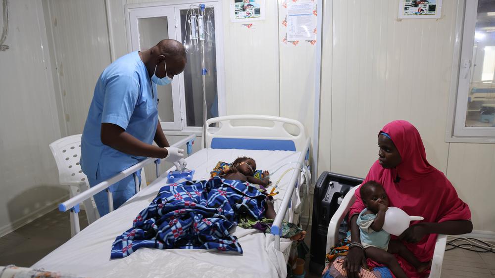 Doctors Without Borders nurse attends to a critically ill child admitted at the emergency room of Nilefa kiji while the mother looks on. Nigeria, 2023.