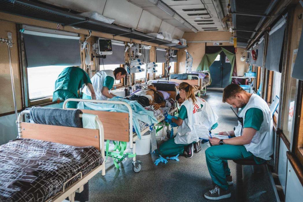The medical team inside the intensive care unit (ICU) of the Doctors Without Borders medical train monitor and stabalise a seriously war-wounded patient during the journey from Pokrovsk, eastern Ukraine to Lviv, in western Ukraine. Ukraine, May 2022. © Andrii Ovod