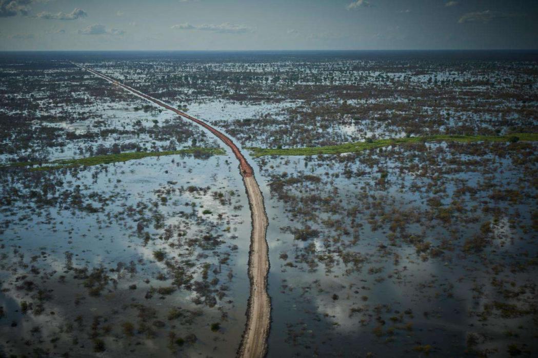 An aerial view of a road and dykes being built by the UN in Bentiu. The dykes are up to 2.5 metres high and 5 metres wide. The flooding around Bentiu spans 80km. South Sudan, August 2022. © Christina Simons