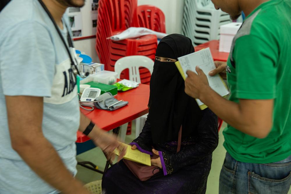 A patient sits as MSF staff member give her some documentation at MSF’s mobile clinic in Bukit Gudung, Penang.