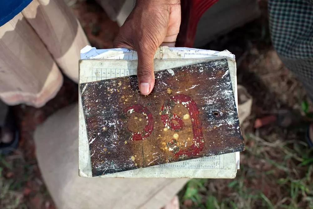 A close-up of the house number in Abdulshakour's hands, a cherished keepsake he holds onto in the hope of returning to his home in Myanmar one day.