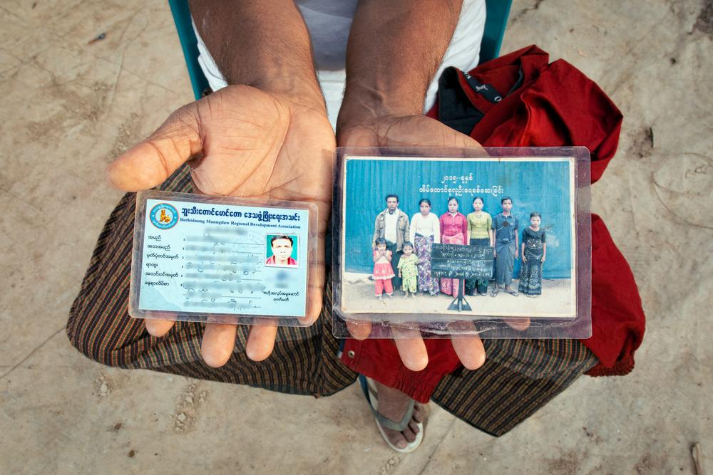 Habibullah holds his driver's license alongside a family photo, tangible memories of the life he once had in Myanmar and among the select items he carried during his departure.