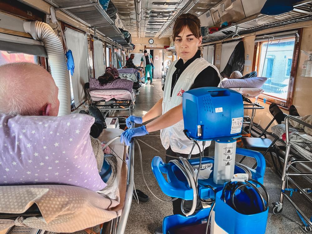 MSF nurse, Halyna Milovus, checks the blood pressure of a patient on the MSF medical evacuation train. Ukraine, 2023. © Verity Kowal/MSF