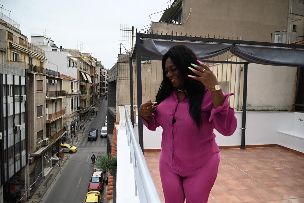 Yuli looks onto the street below from the MSF day centre’s terrace in Athens. She fled persecution in Cuba and now lives in Greece, where she is committed to connecting the Cuban transgender community with healthcare and social services. Athens, Greece, January 2023.  © Mero Verli/MSF