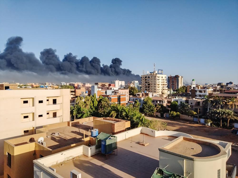 An aerial view shows black smoke drifting across Khartoum following the fighting and violence that erupted between the army and paramilitary forces in mid-April. Khartoum, Sudan, May 2023. © Atsuhiko Ochia/MSF