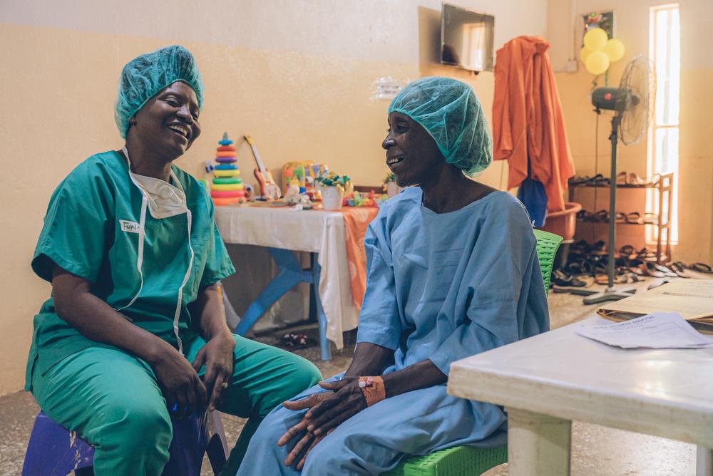 Doctors Without Borders counsellor from the mental health department, talks to a Noma survivor from Yobe state, before her surgery. Nigeria, May 2023. © Fabrice Caterini/Inediz