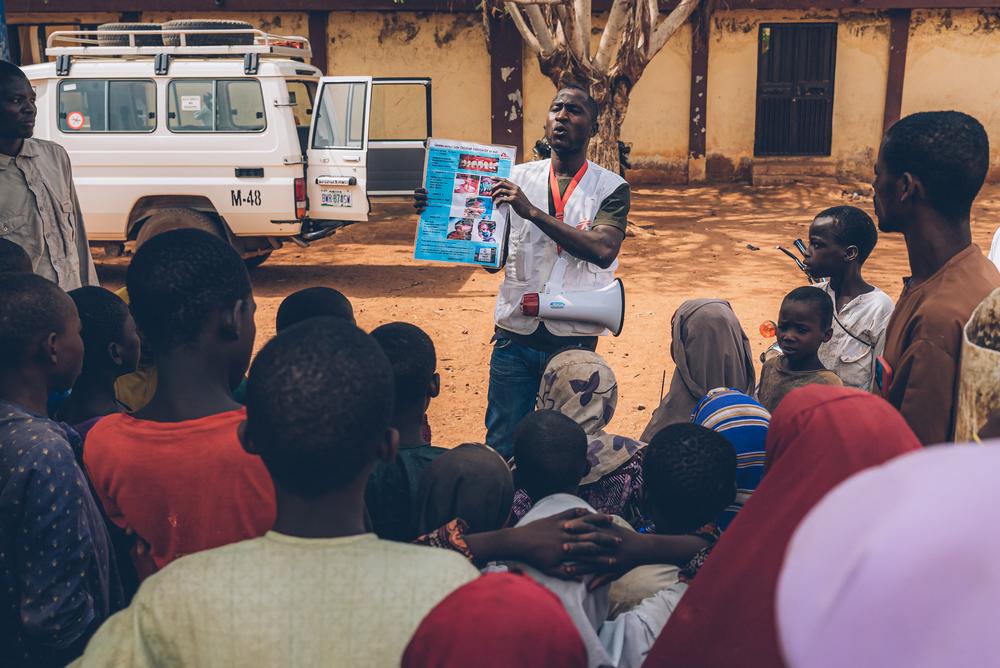 The outreach team of the Noma Hospital in Sokoto, Nigeria, is showing leaflets to check if someone identifies a noma case in the area. Nigeria, May 2023. © Fabrice Caterini/Inediz