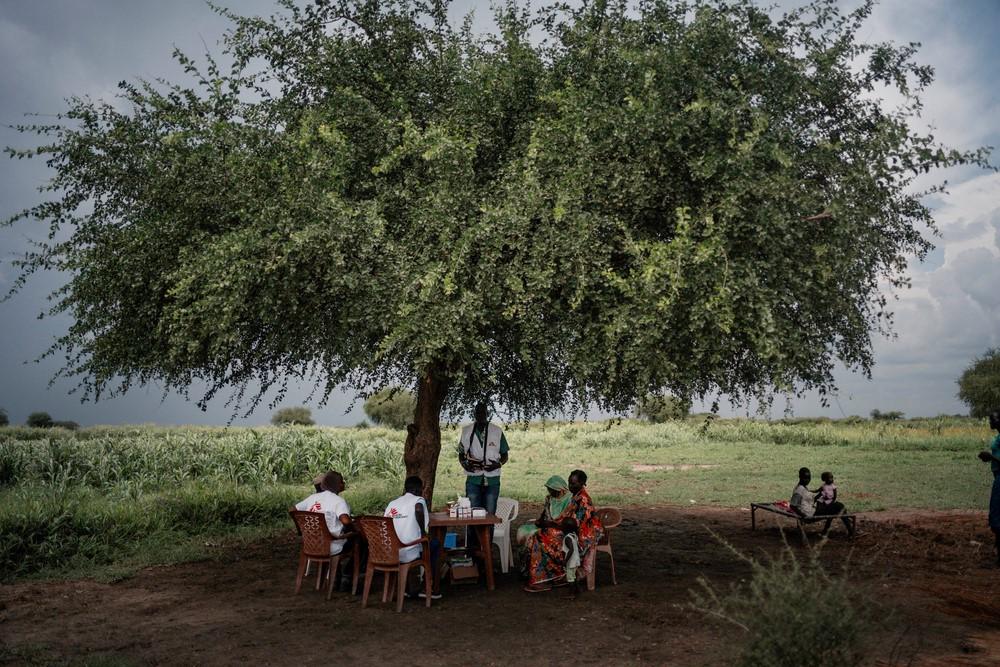 An MSF team provides medical consultations to people in the village of Khadian, at a temporary health post set up under a tree. Abyei Special Administrative Area (contested area between South Sudan and Sudan), August 2023.  © Sean Sutton/Panos Pictures