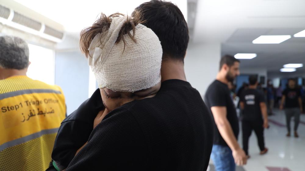 A young boy injured by an airstrike in Gaza hugs his father after receiving treatment at Al-Shifa hospital. Gaza Strip, Palestine, 19 October 2023.  © Mohammad Masri